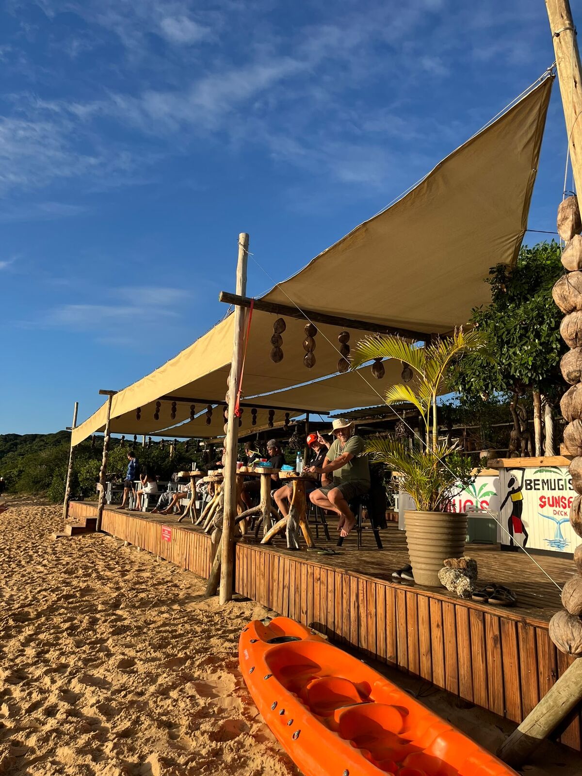 Beach deck bar at sunset with kayak on the sand