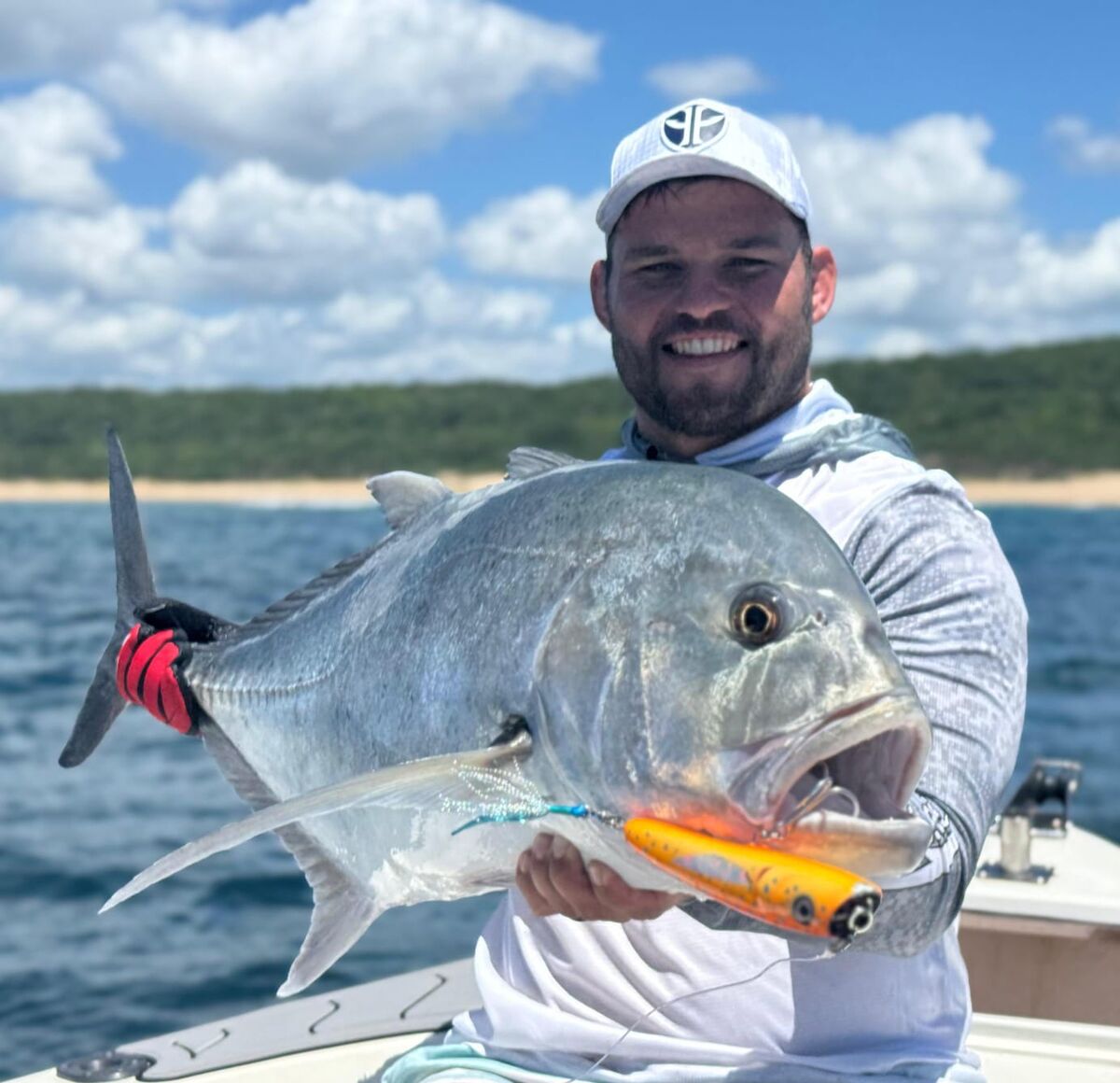 Angler with a giant trevally caught on a popper lure