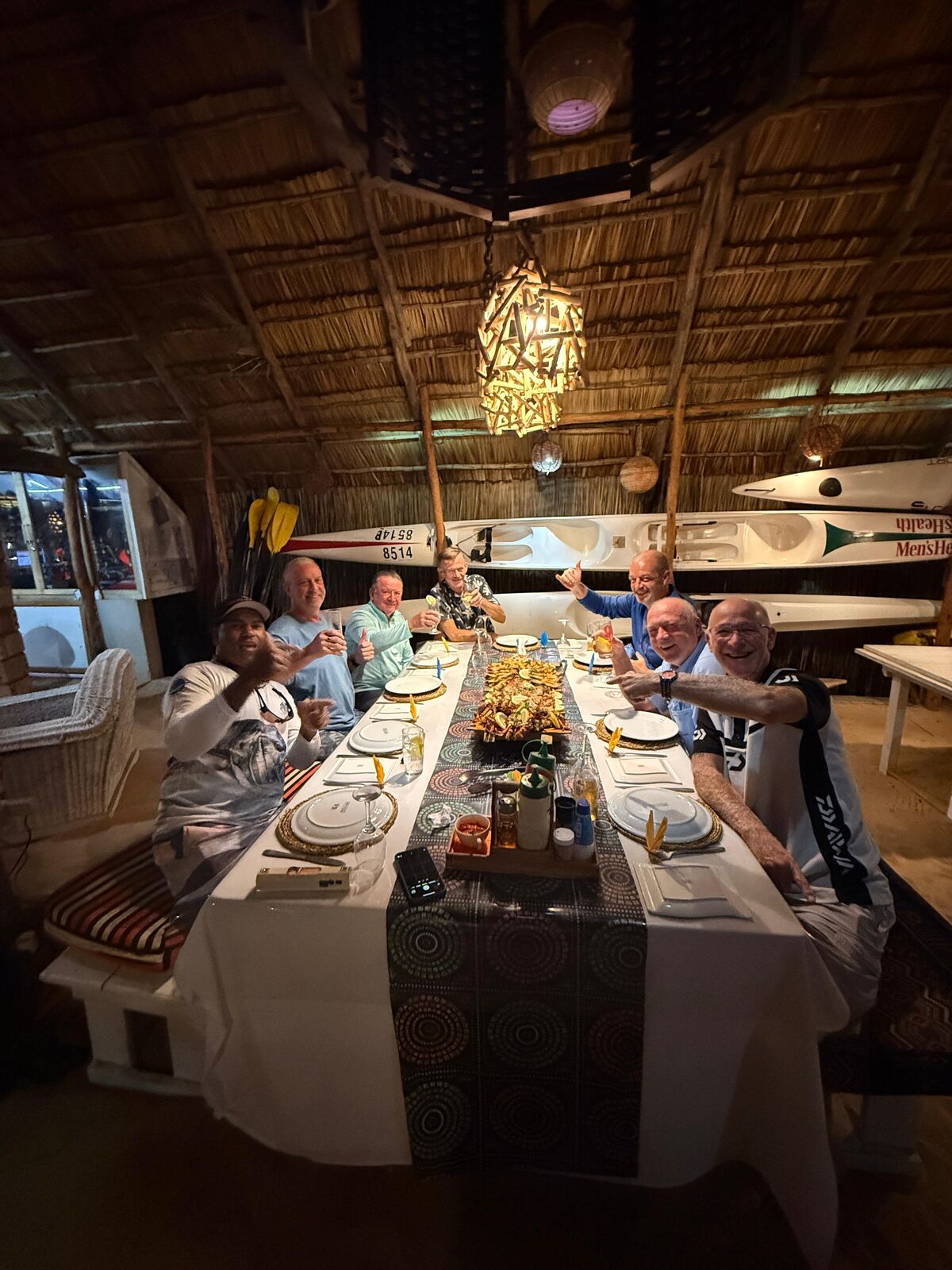 Guests sharing dinner under a thatched roof at the lodge