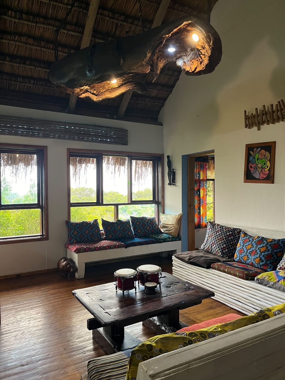 Thatched lodge lounge with ocean-view windows