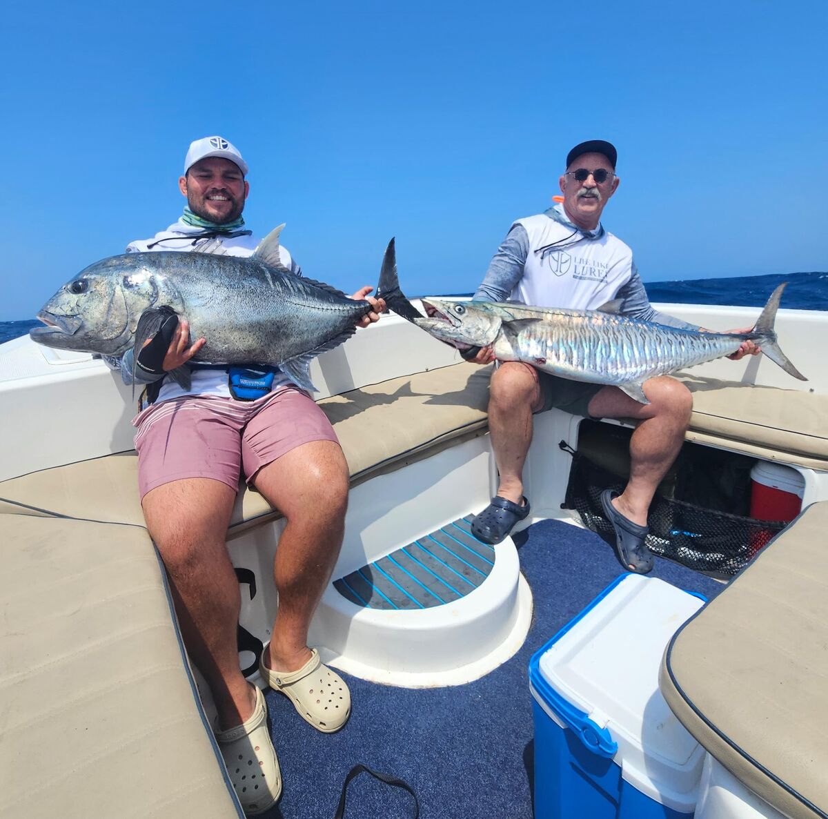 Two anglers holding yellowfin tuna on a WildTide offshore charter